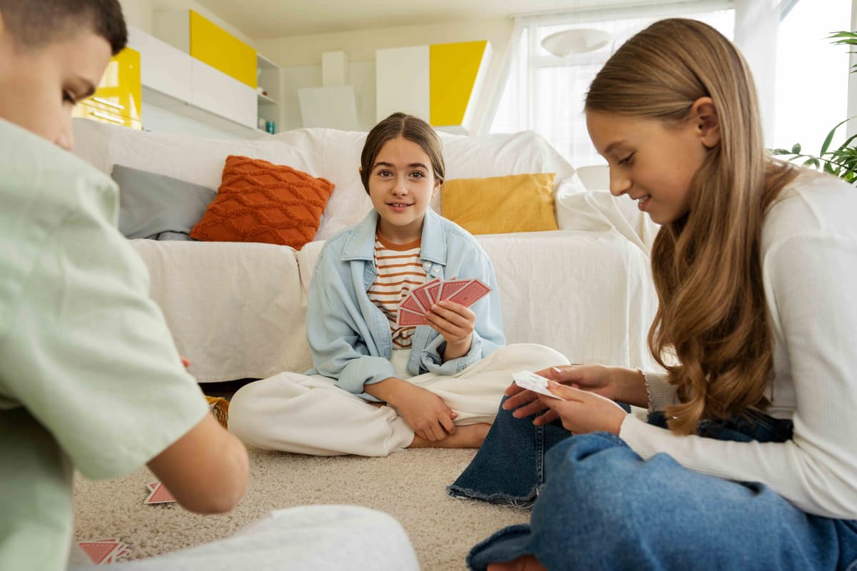 Kinder spielen gemeinsam Karten in einem warmen, wohnlichen Raum